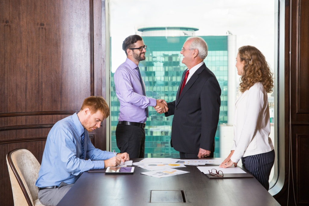 businessmen-shaking-hands-while-another-is-writing.jpg подпись